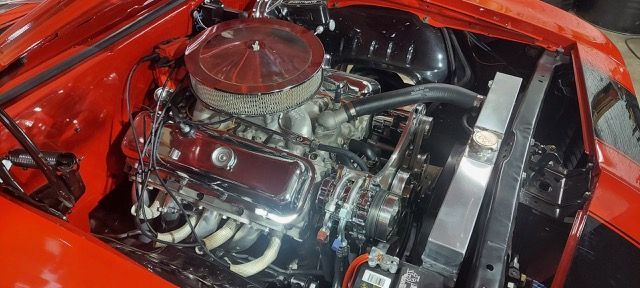 Red car engine bay with polished chrome engine and red air cleaner cover