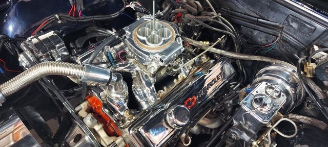 Chrome car engine with polished V8 components in a black engine bay