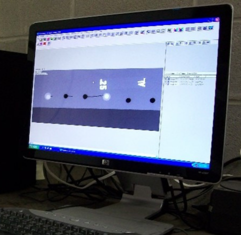 A computer monitor displays a software interface showing a row of dark circular icons on a gray background.