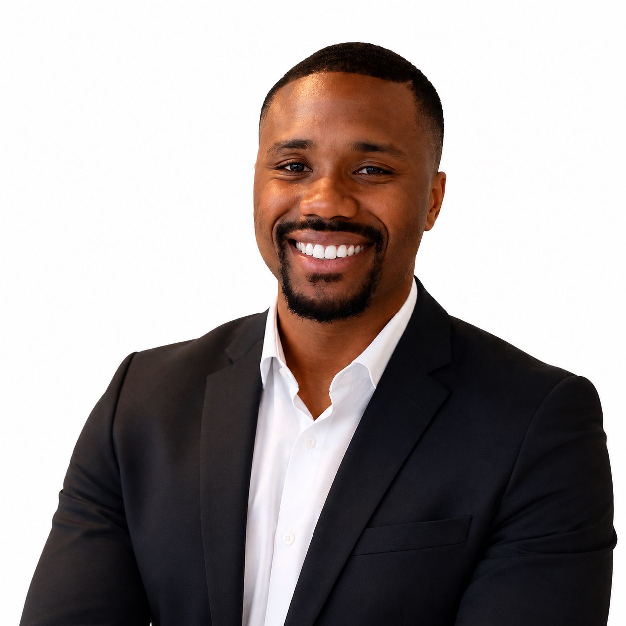 Homme souriant en costume noir et chemise blanche sur fond blanc