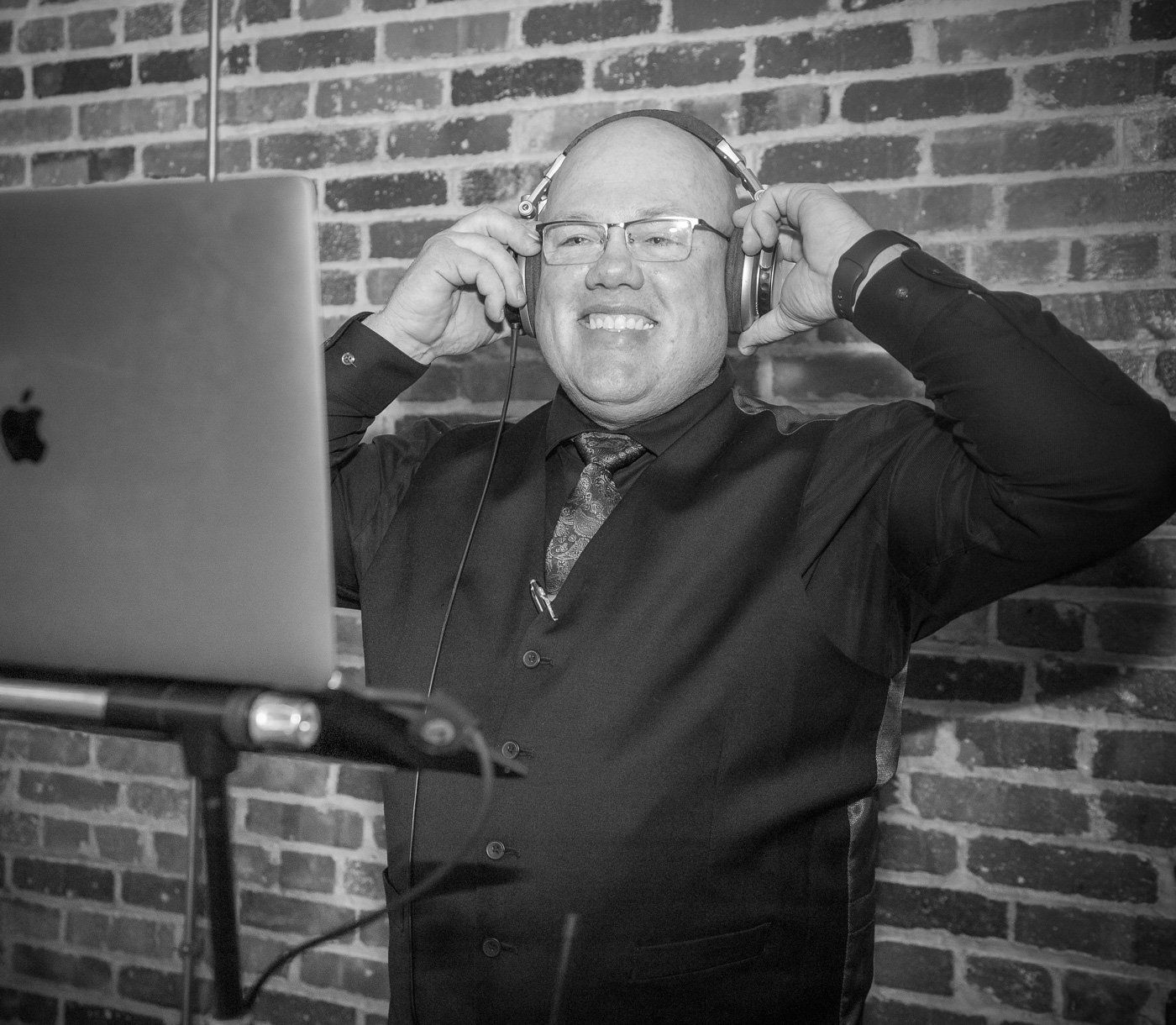 Seasoned wedding DJ Aaron bracken adjusts his headphones while taking the stress out of your reception.
