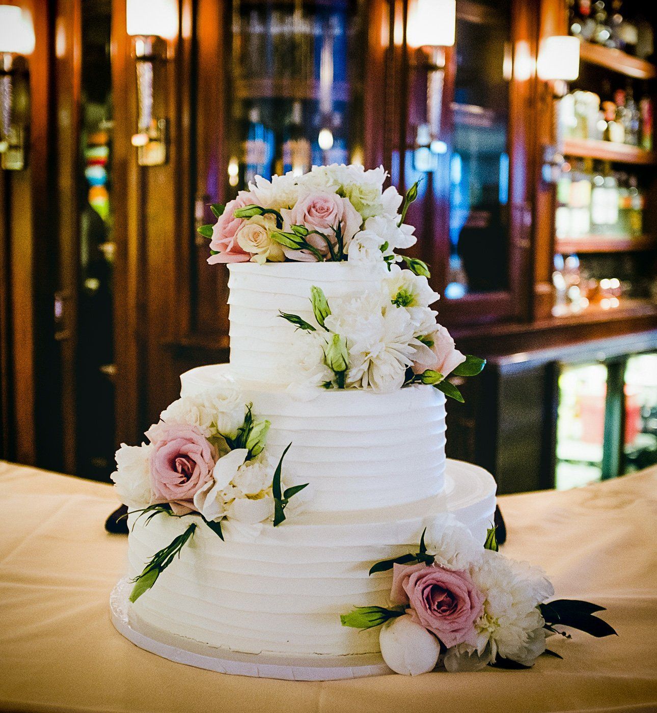 Wedding cake sits on a bar at a central indiana local reception venue.