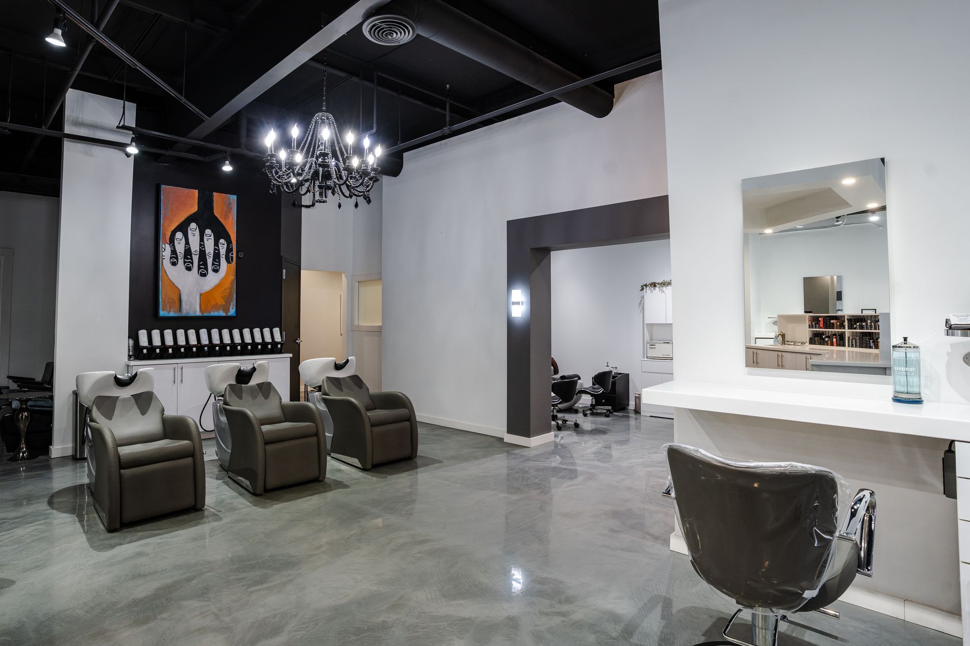 Hair salon interior with styling chairs, sinks, and art.