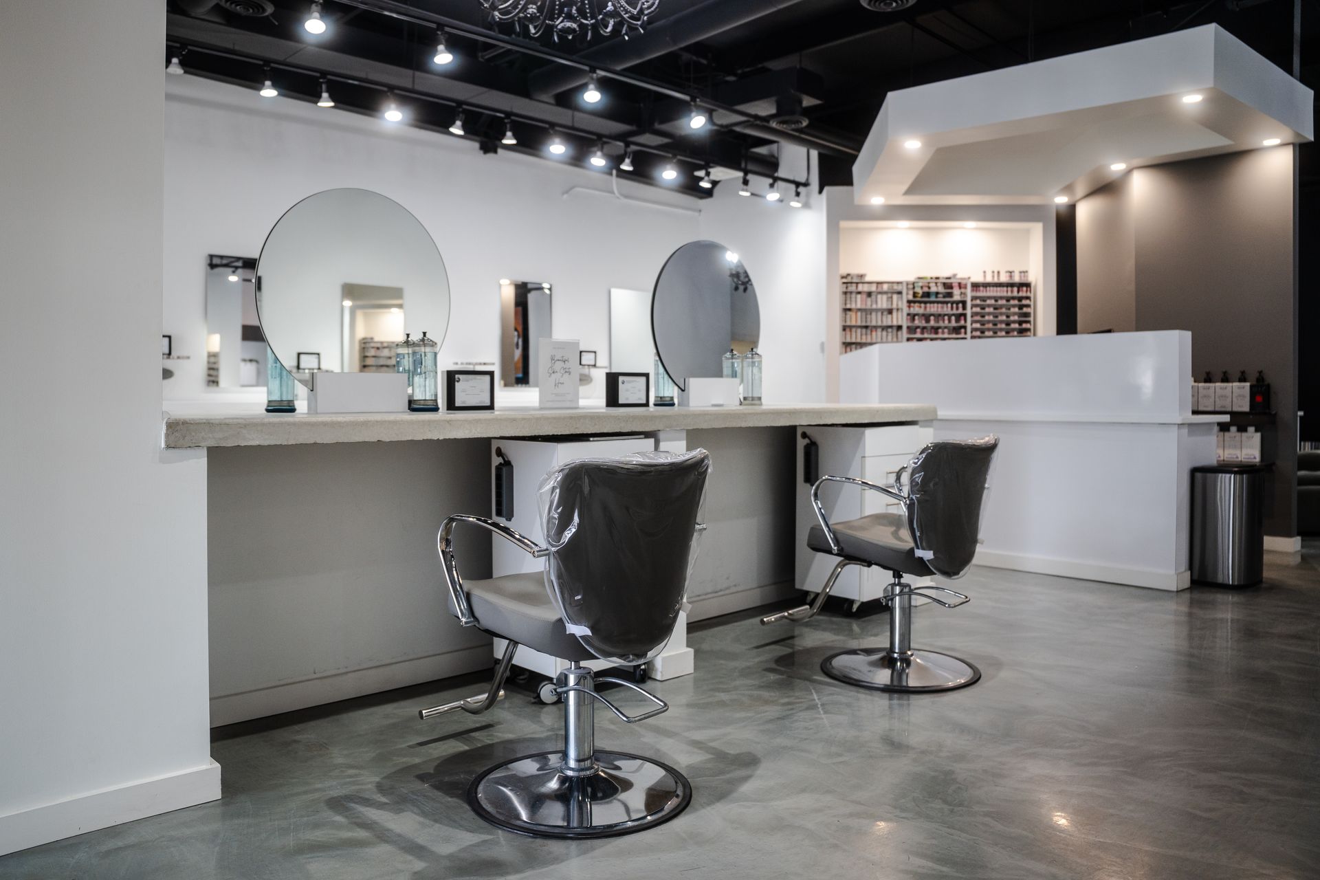 Hair salon interior with mirrors, chairs, and styling stations.