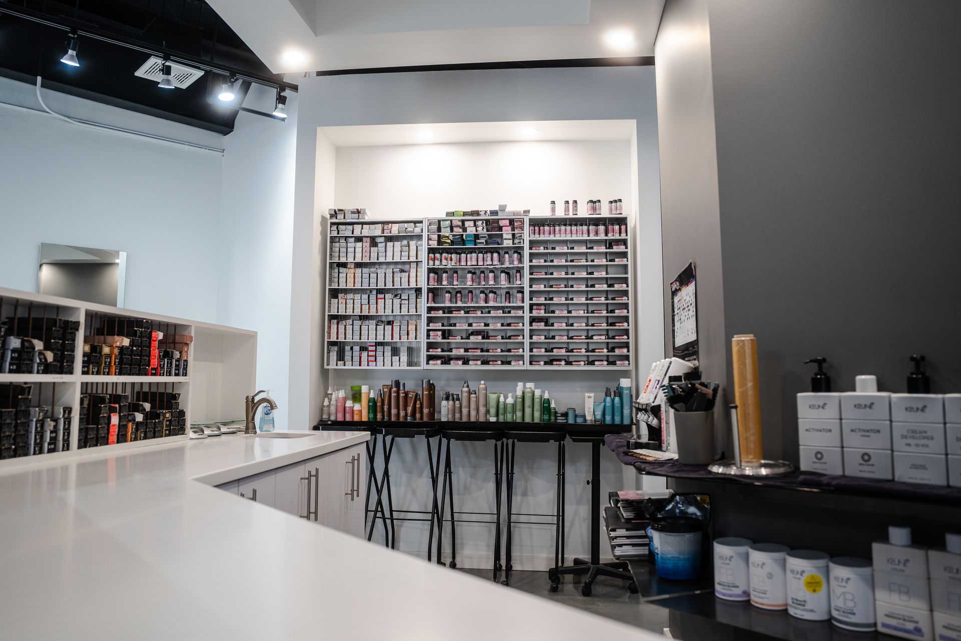 Hair salon interior with a product display shelf behind a counter.