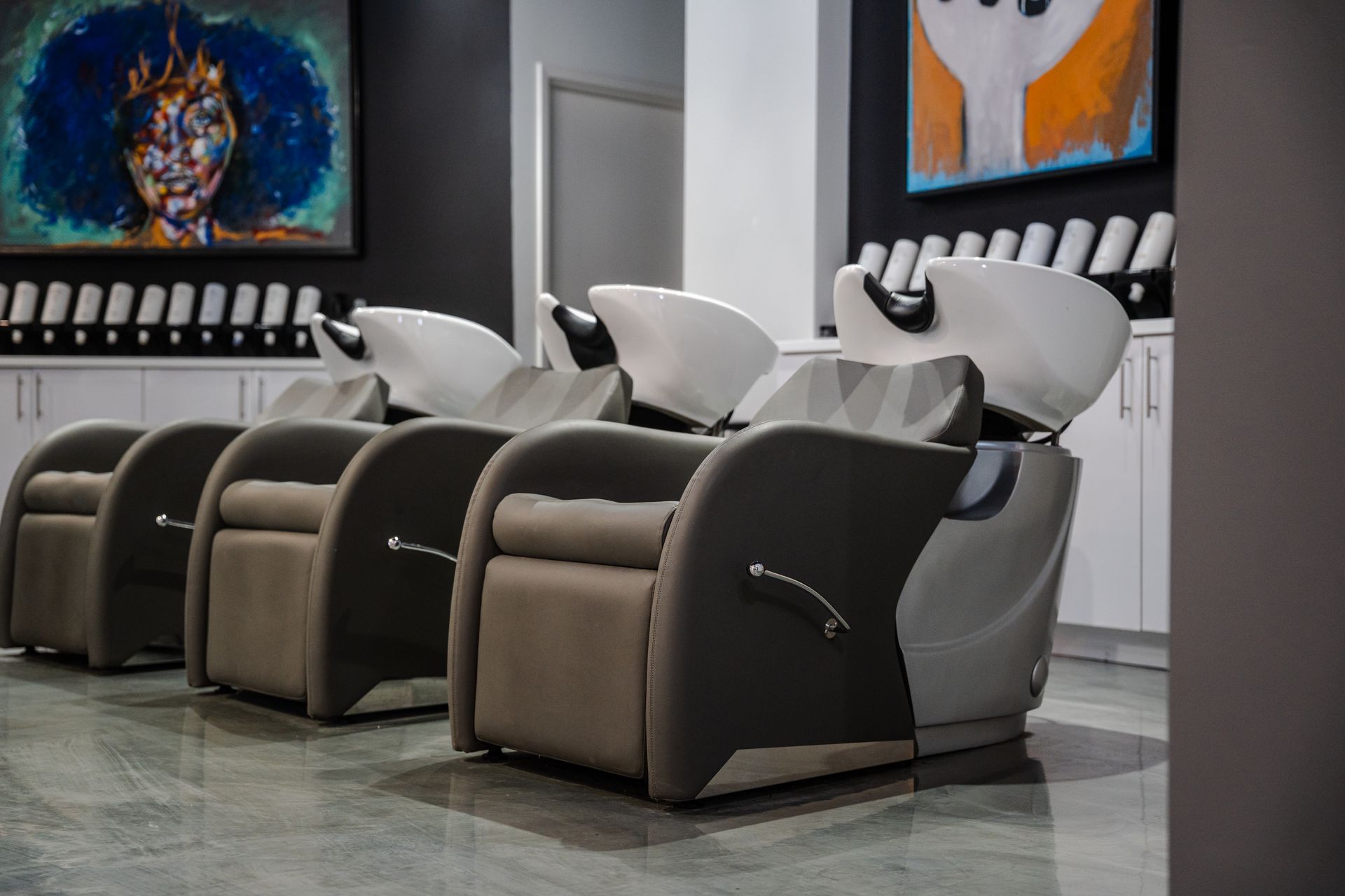 Hair salon with shampoo chairs and art.