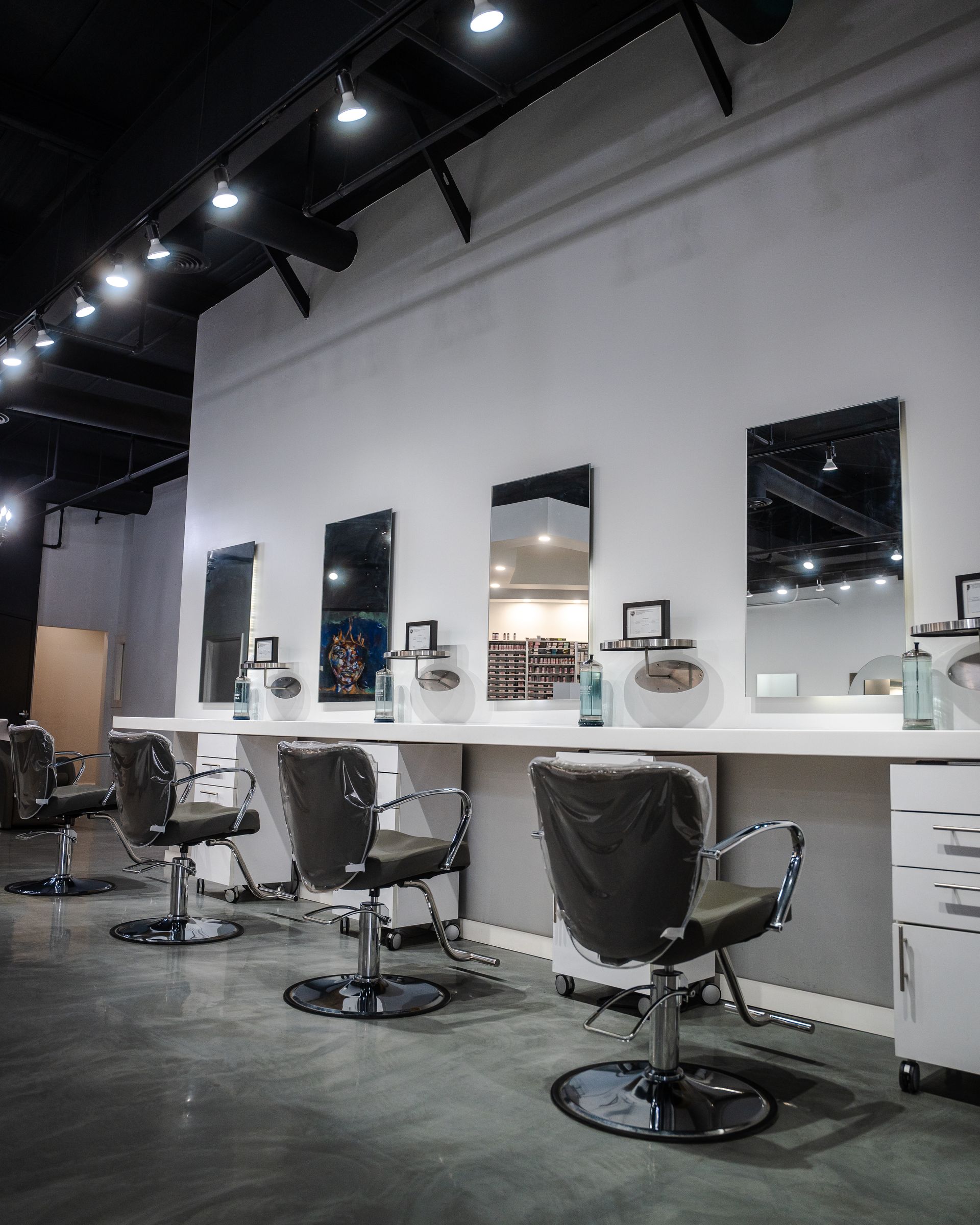 Hair salon interior with mirrors, chairs, and styling stations.