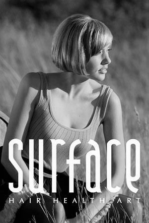 Woman with short blonde hair looking to the right, wearing a tank top, sitting outside;