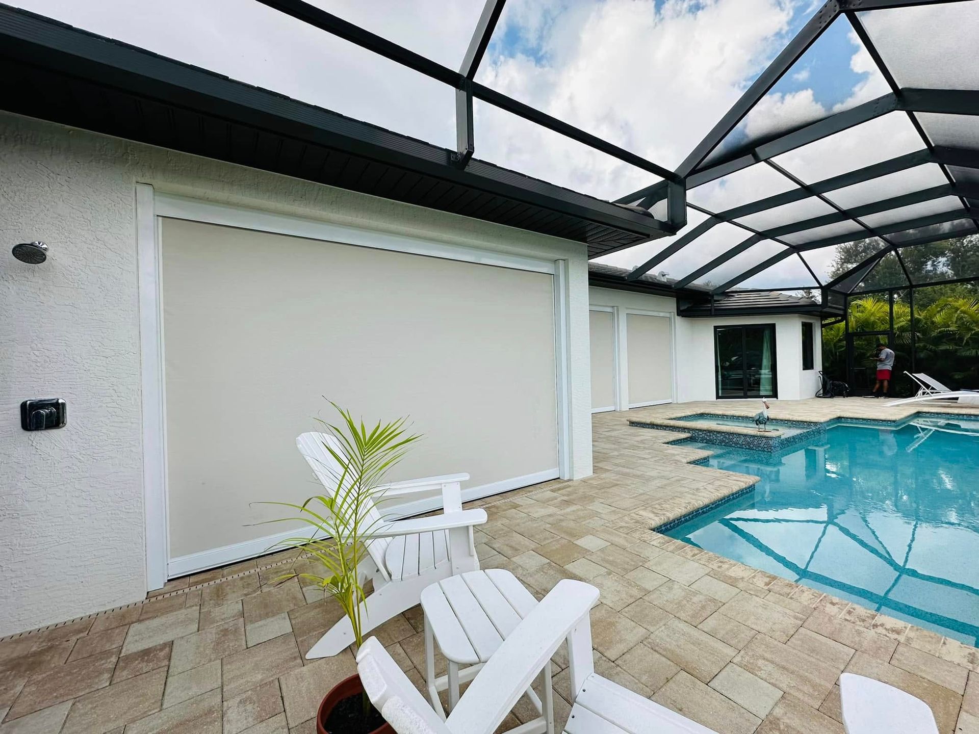Patio with swimming pool, tiled deck, lounge chair, and screened enclosure