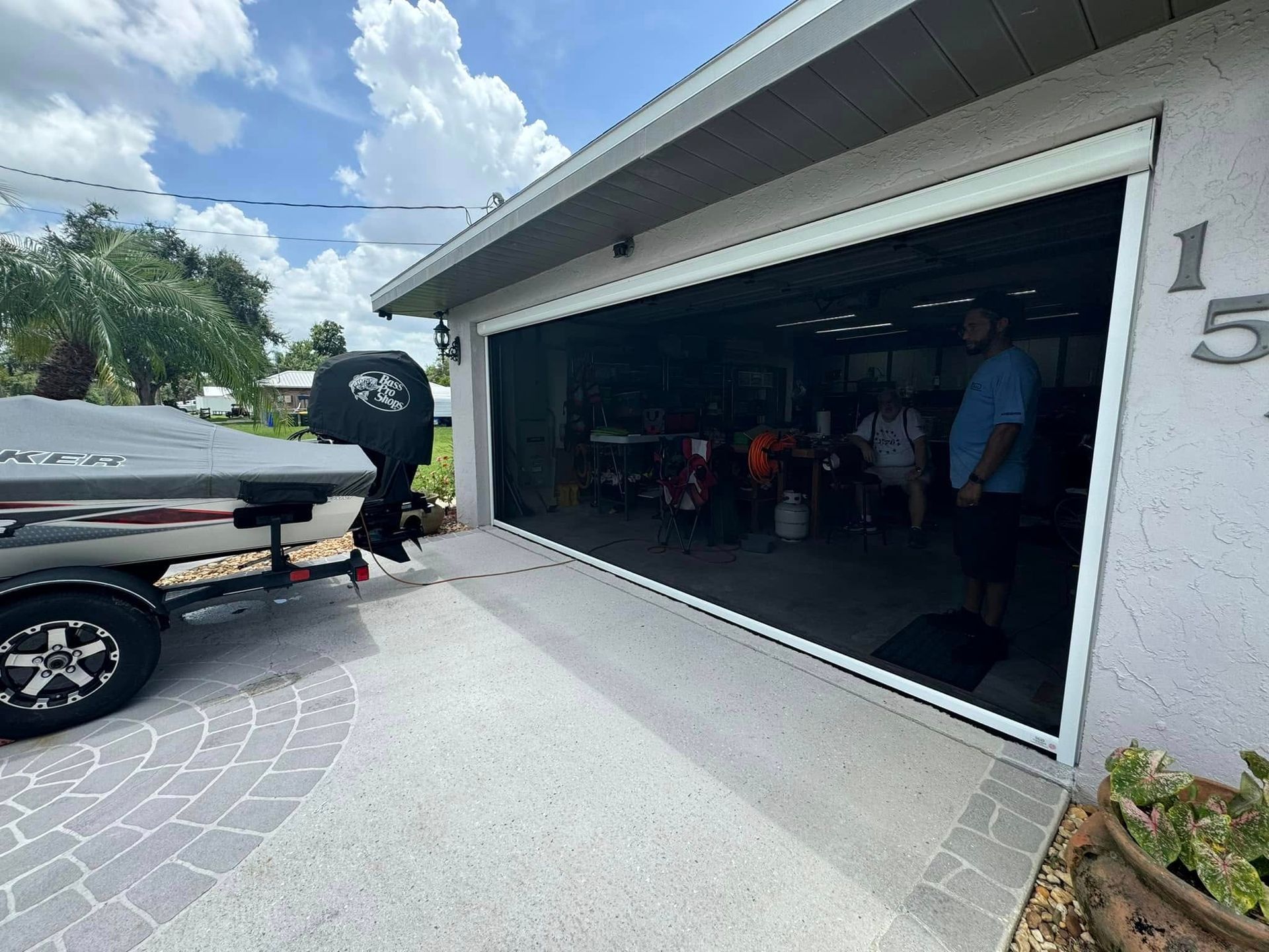 Open garage with a truck parked outside and people inside, numbered 15 on the wall