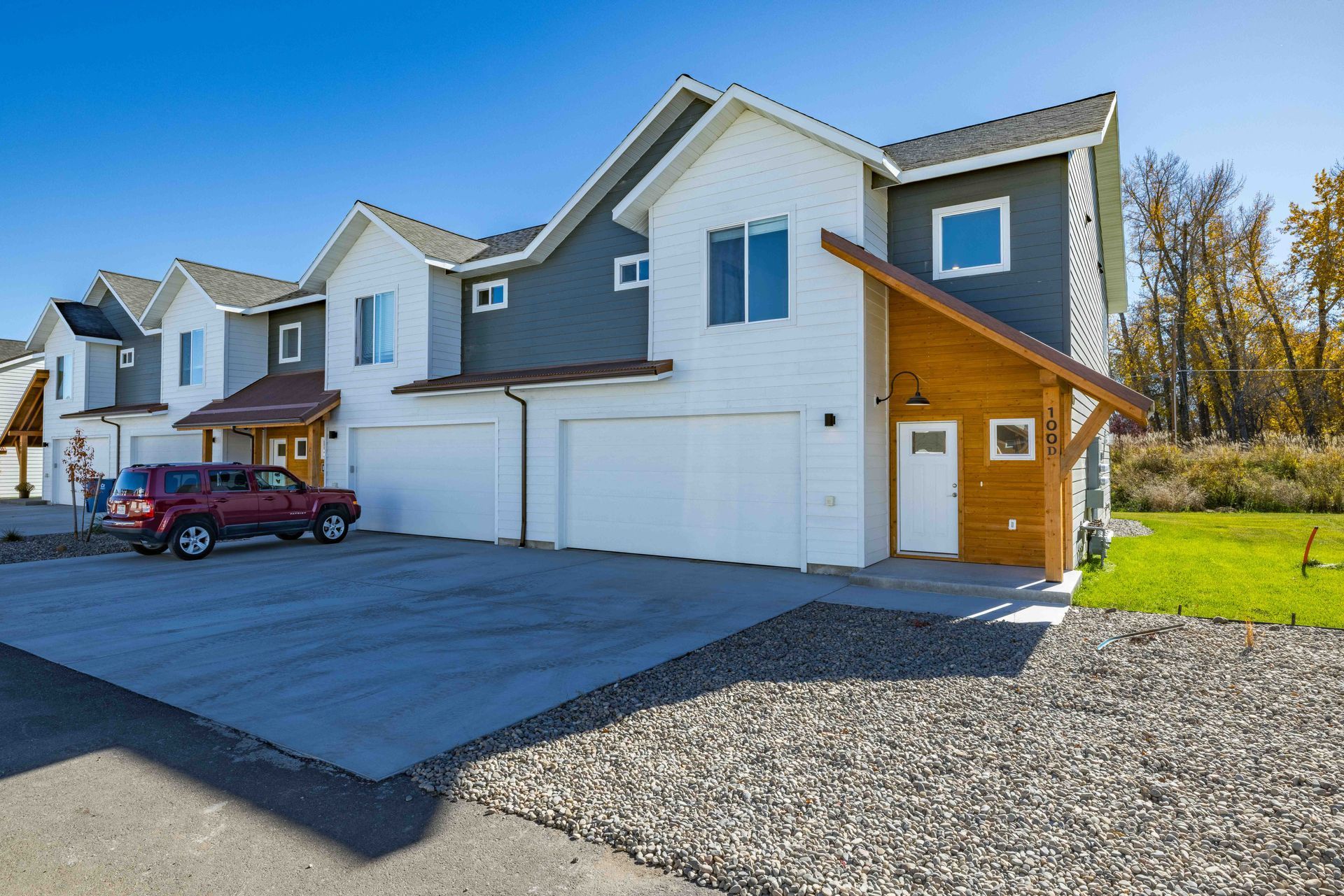 A row of houses with cars parked in front of them