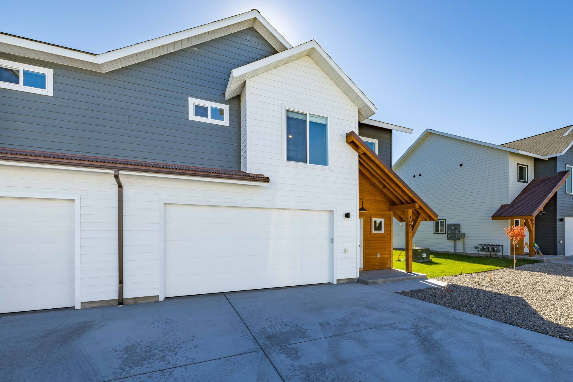 A white and gray house with two garage doors