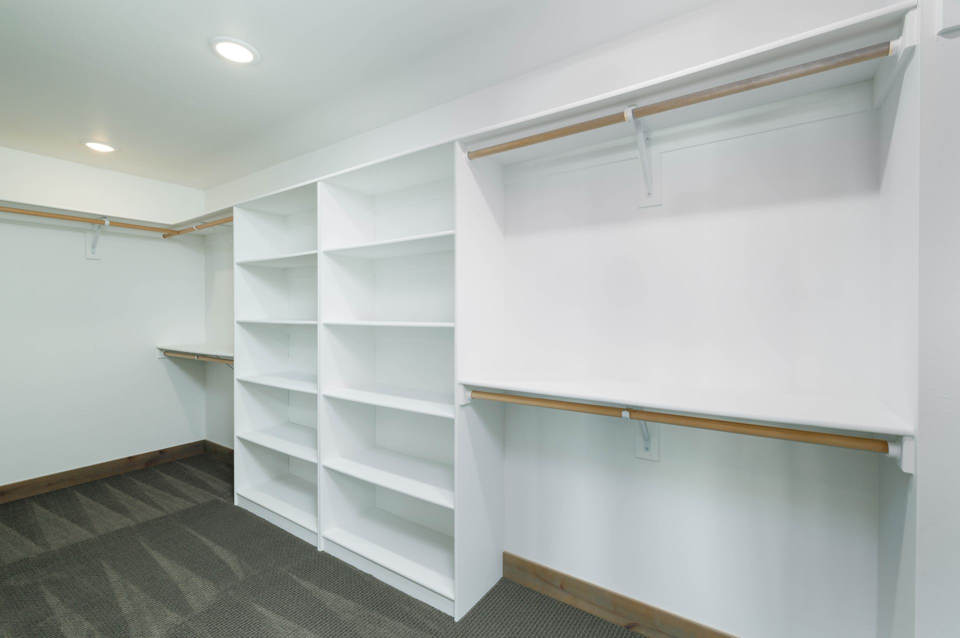 A walk in closet with lots of shelves and hanging racks.