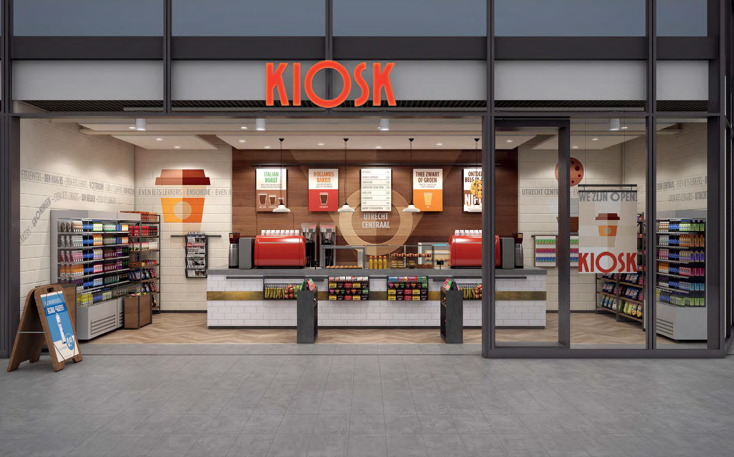 De gevel van een kiosk met glazen deuren, rode bewegwijzering en schappen vol snacks en drankjes.