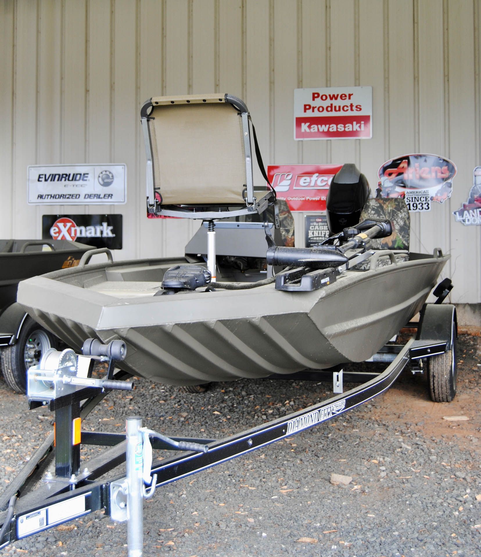 A boat is on a trailer in front of a sign that says power products