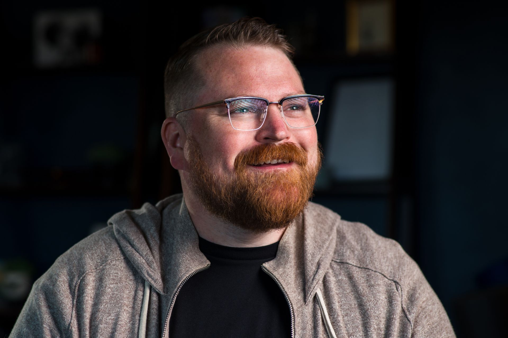 A man with a beard and glasses is smiling.