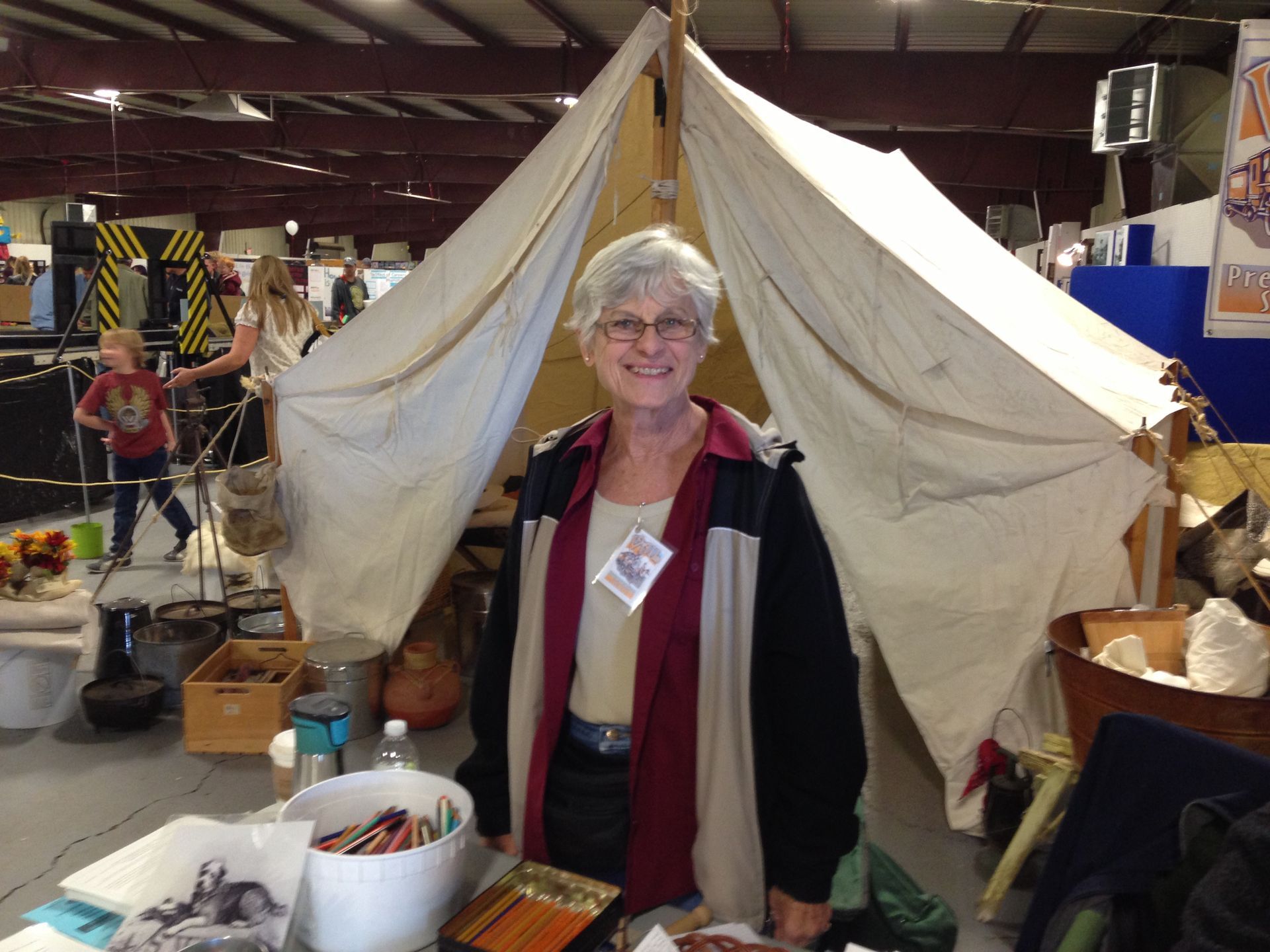A woman is standing in front of a large tent