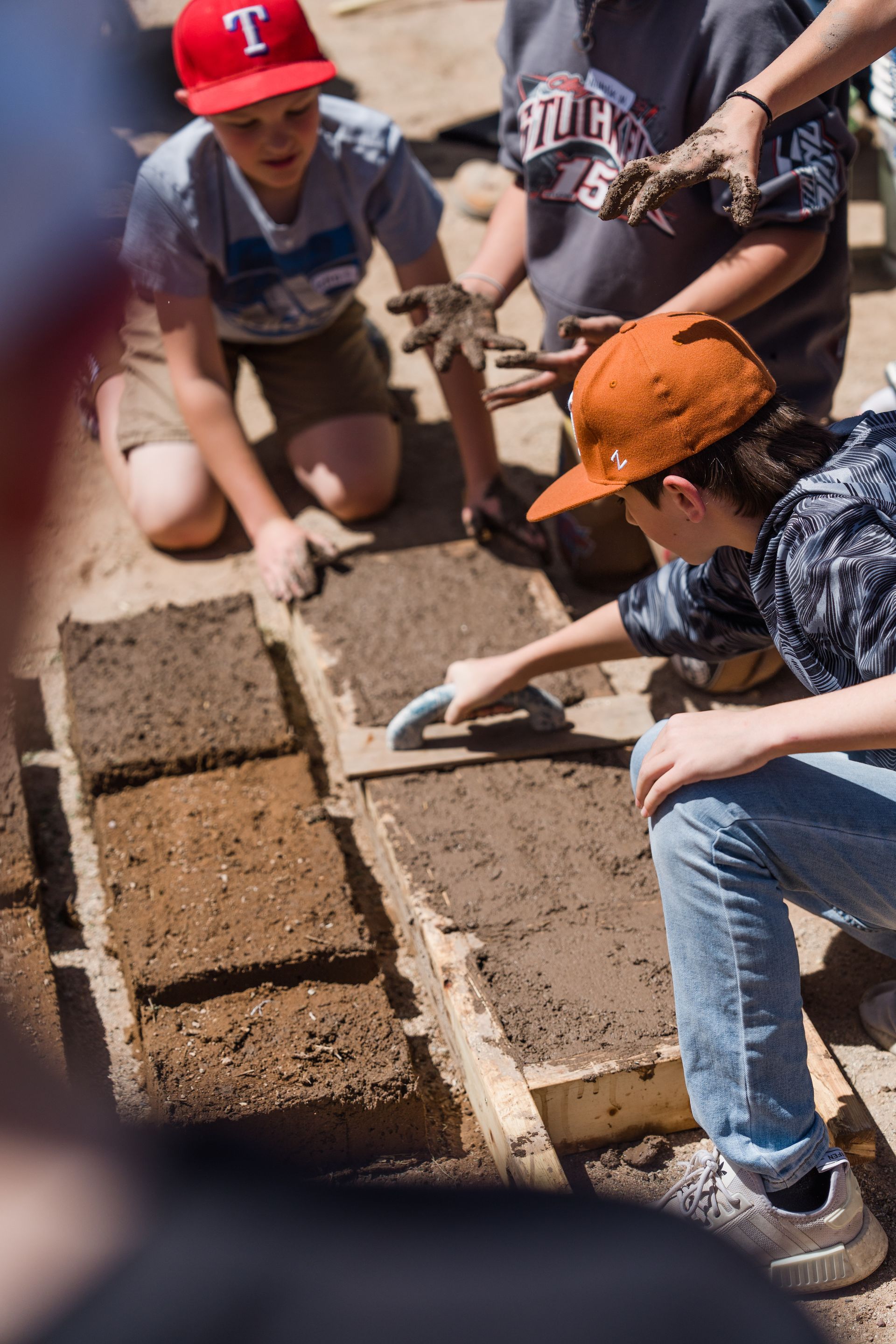A group of people are working on a brick wall.