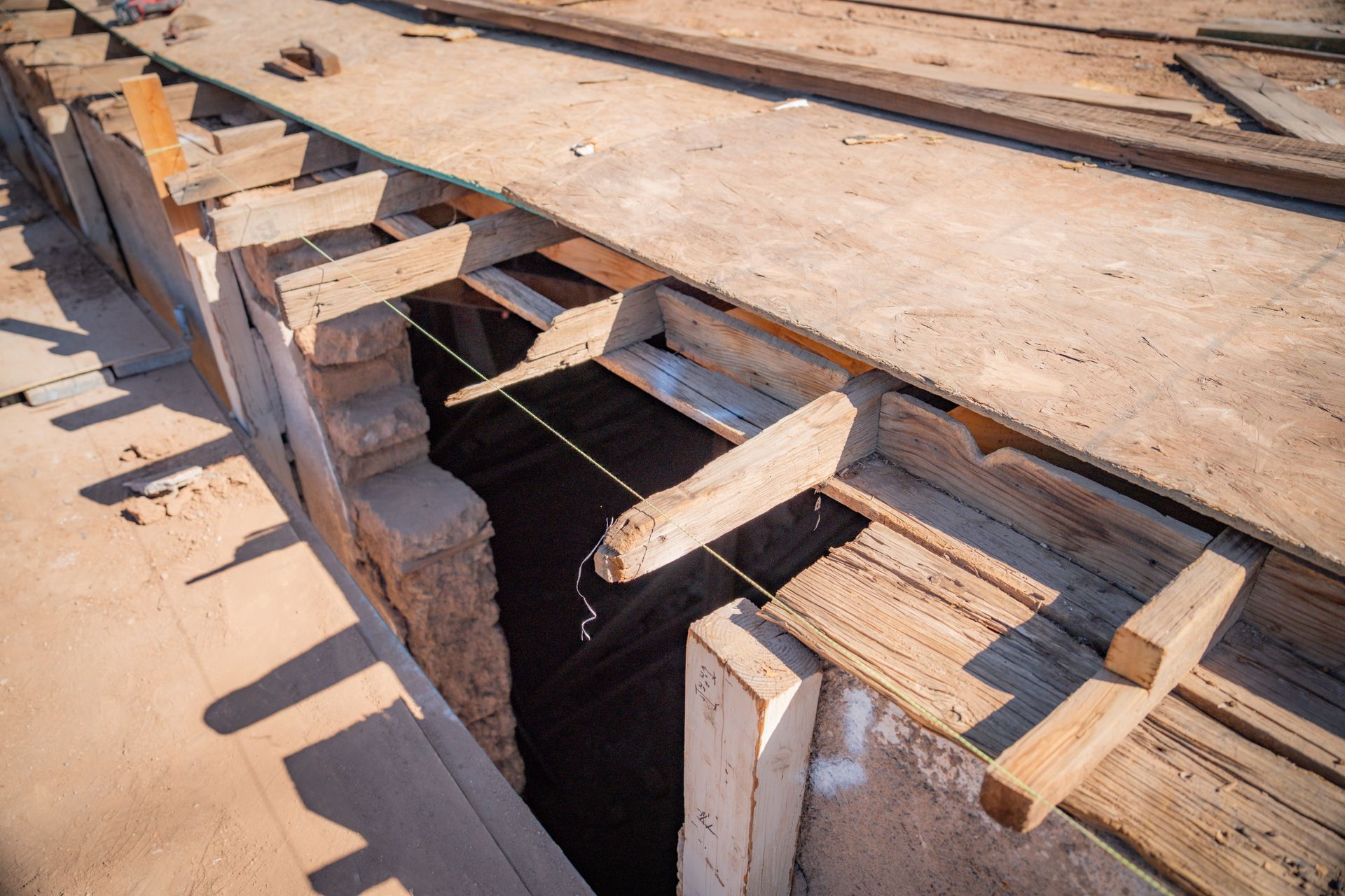 A wooden structure is being built over a hole in the ground.