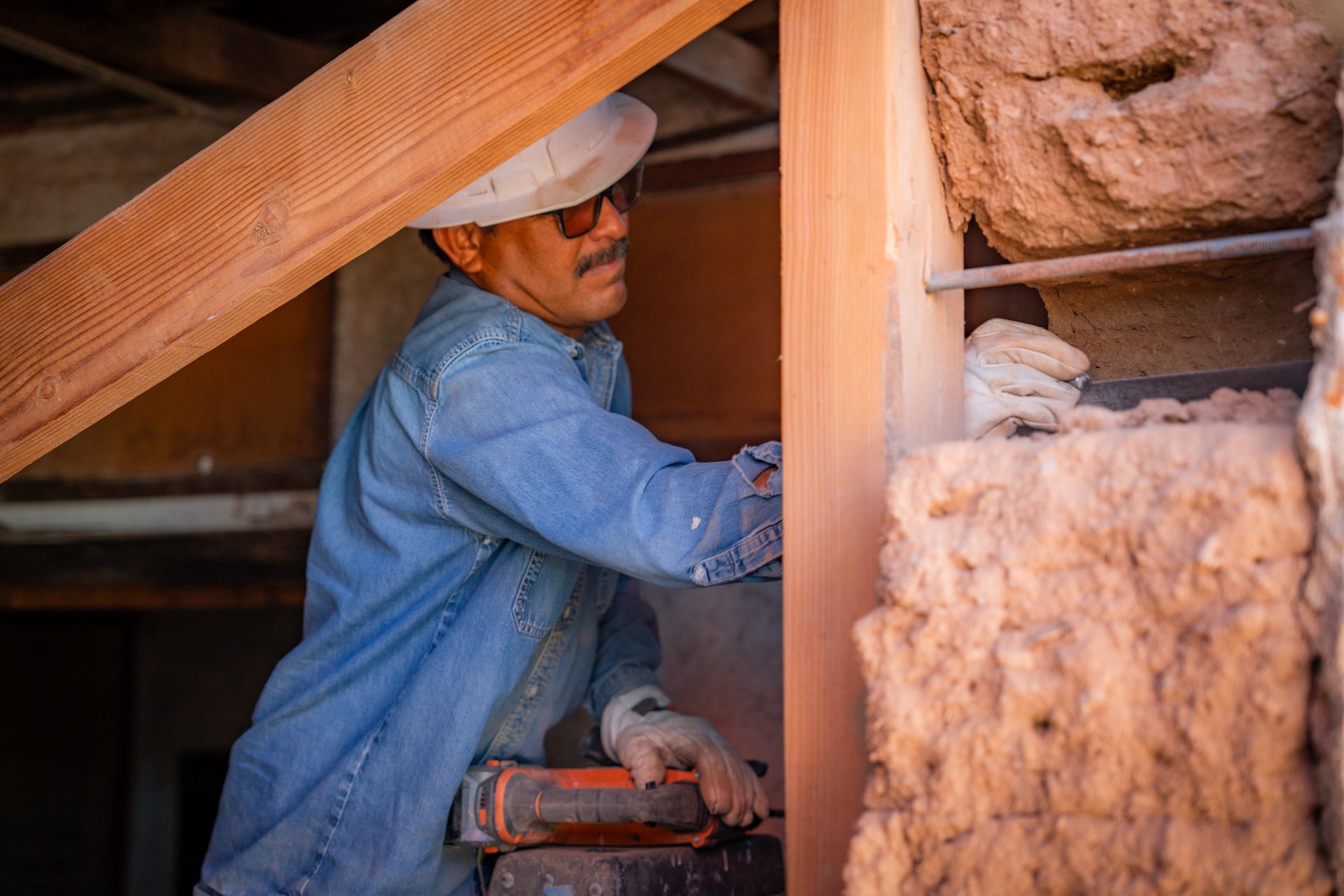 A man is cutting a piece of wood with a saw.