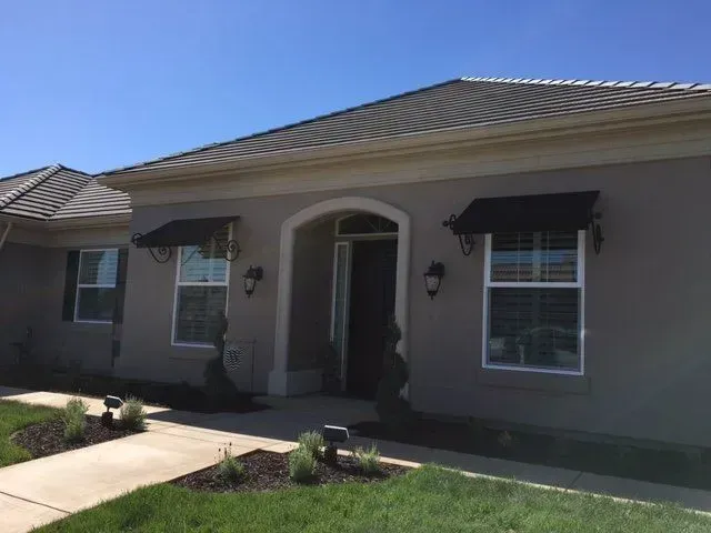 A house with a black awning on the windows