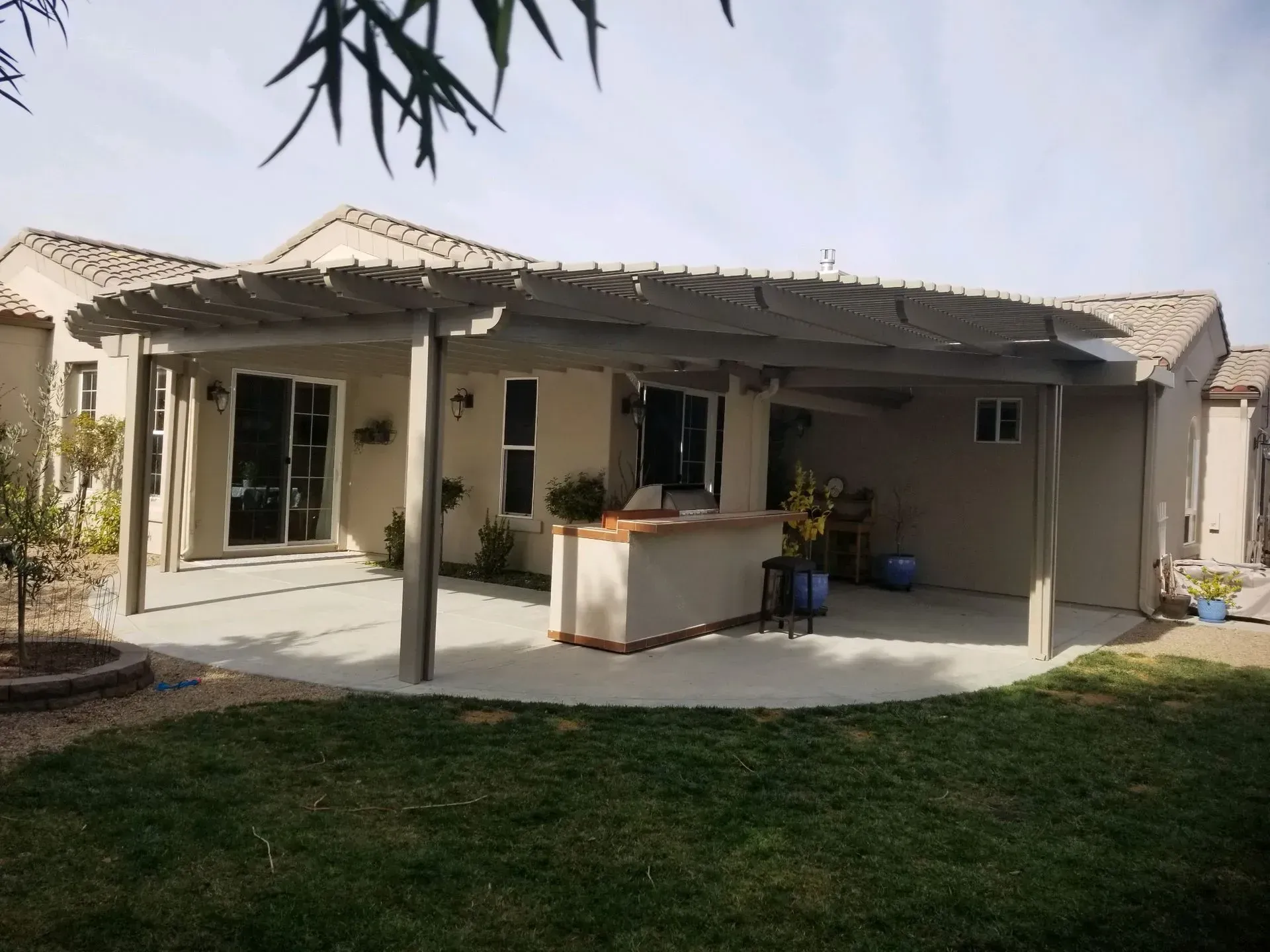 The backyard of a house with a covered patio area