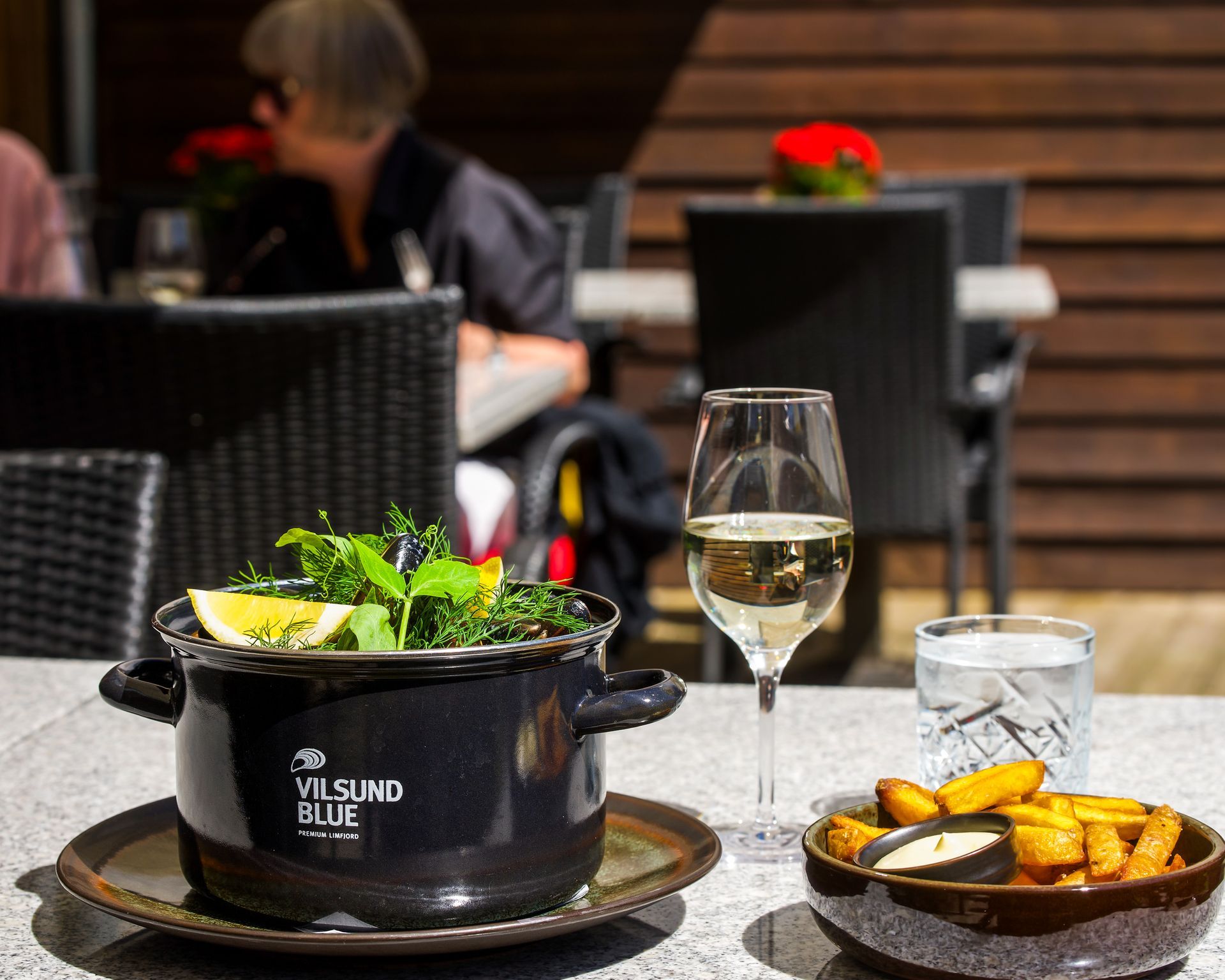 Et bord med mad og drikkevarer på en restaurant. En kande med mad, pommes frites og vin.