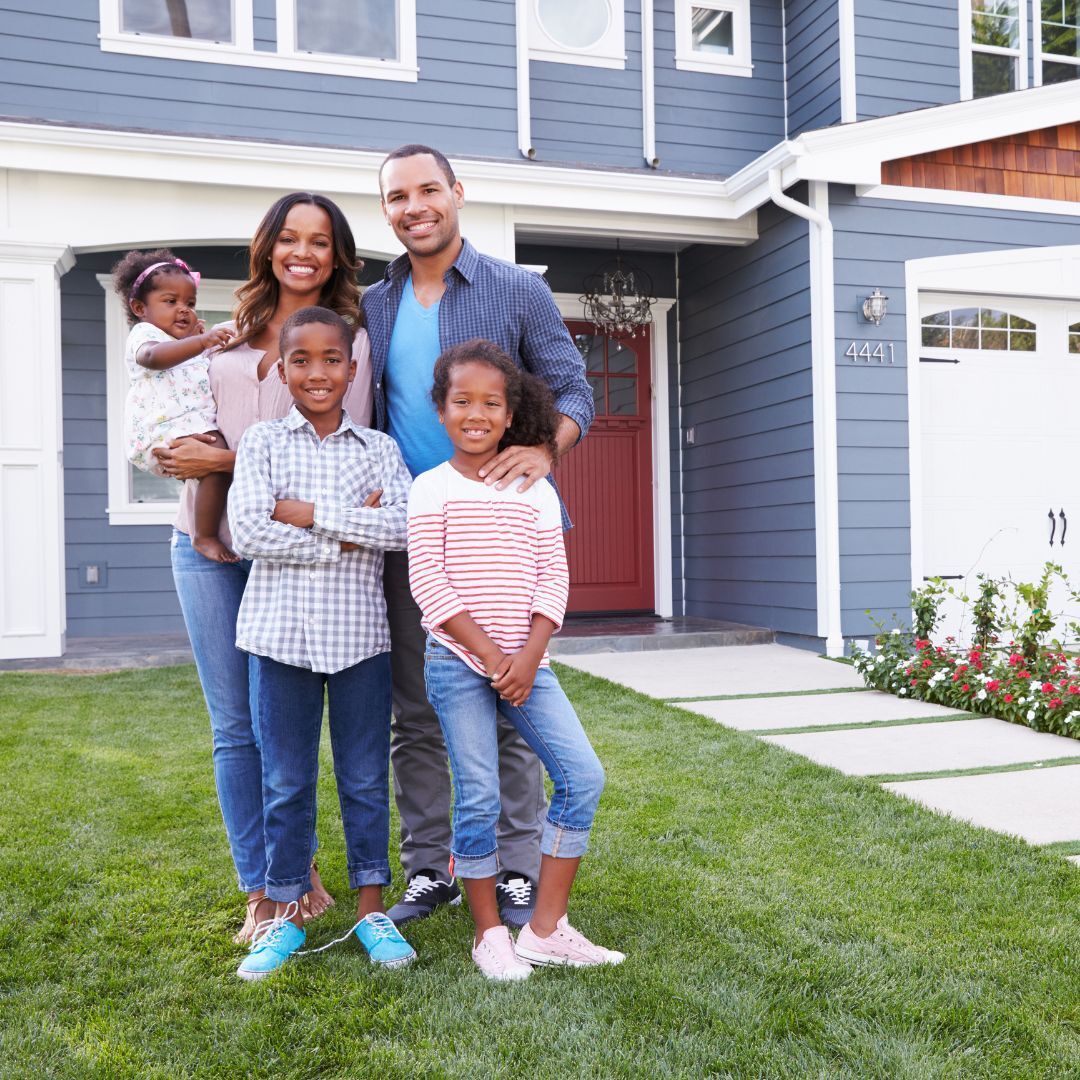 A happy family outside their house with a garage