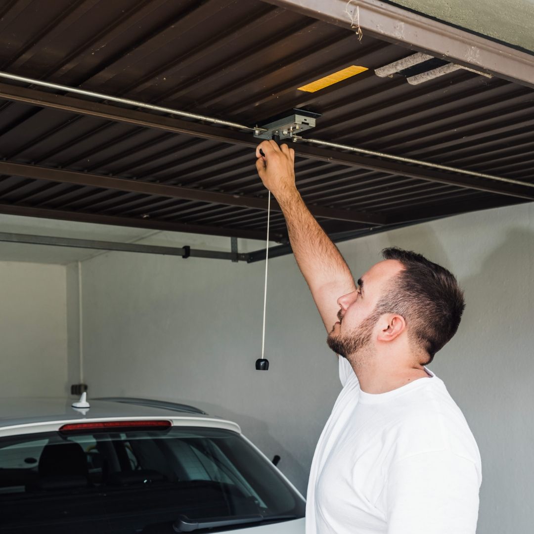 Man closing the garage door with his car inside