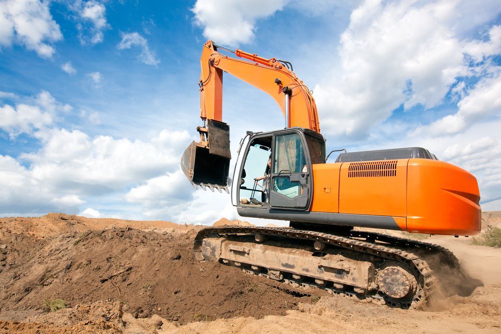 An Orange Excavator Is Moving Dirt On A Construction Site — Gillies Enterprises Pty Ltd In Narrabri, NSW