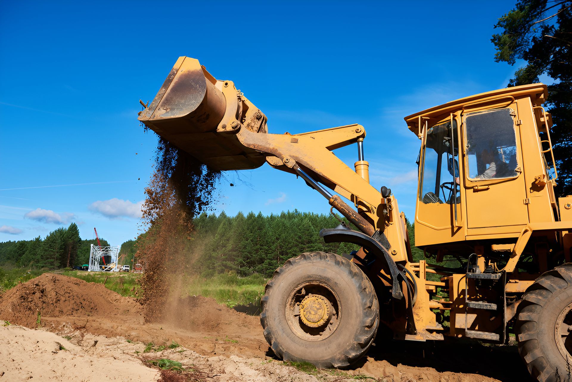 A Yellow Bulldozer Is Loading Dirt Into A Pile — Gillies Enterprises Pty Ltd In Walgett, NSW