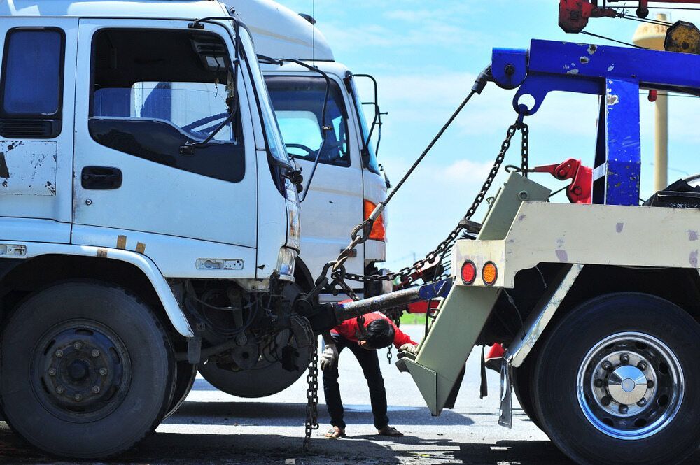 A Truck Is Being Towed By A Tow Truck On A Highway — Gillies Enterprises Pty Ltd In Coonabarabran, NSW