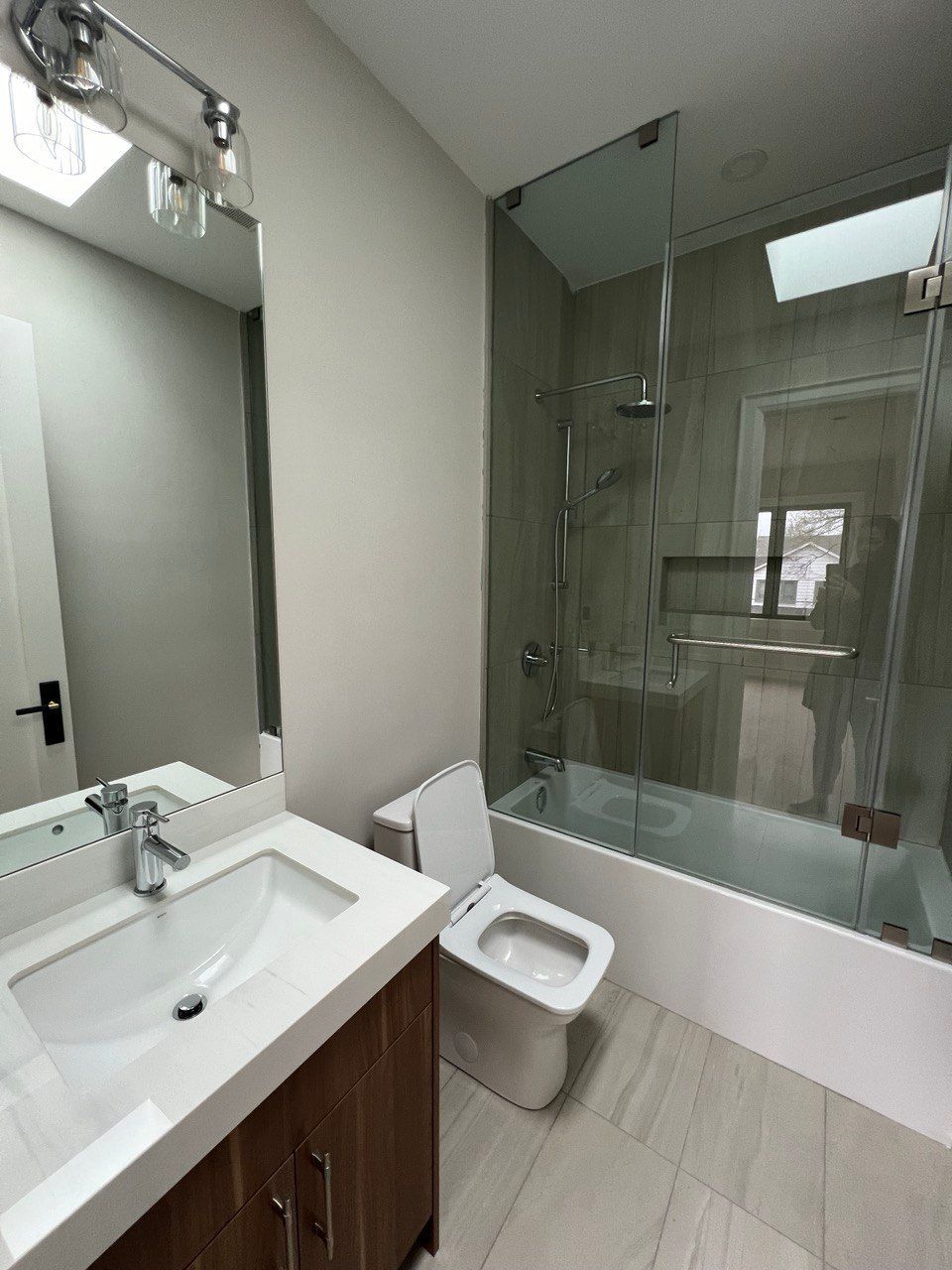 A bathroom with a toilet , sink , and shower.