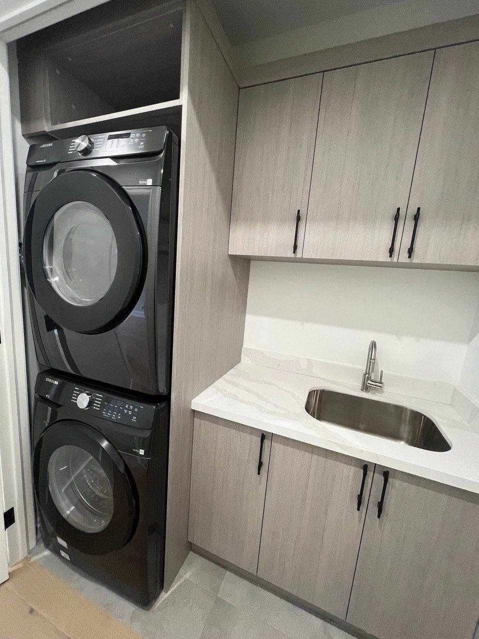 A laundry room with a washer and dryer stacked on top of each other