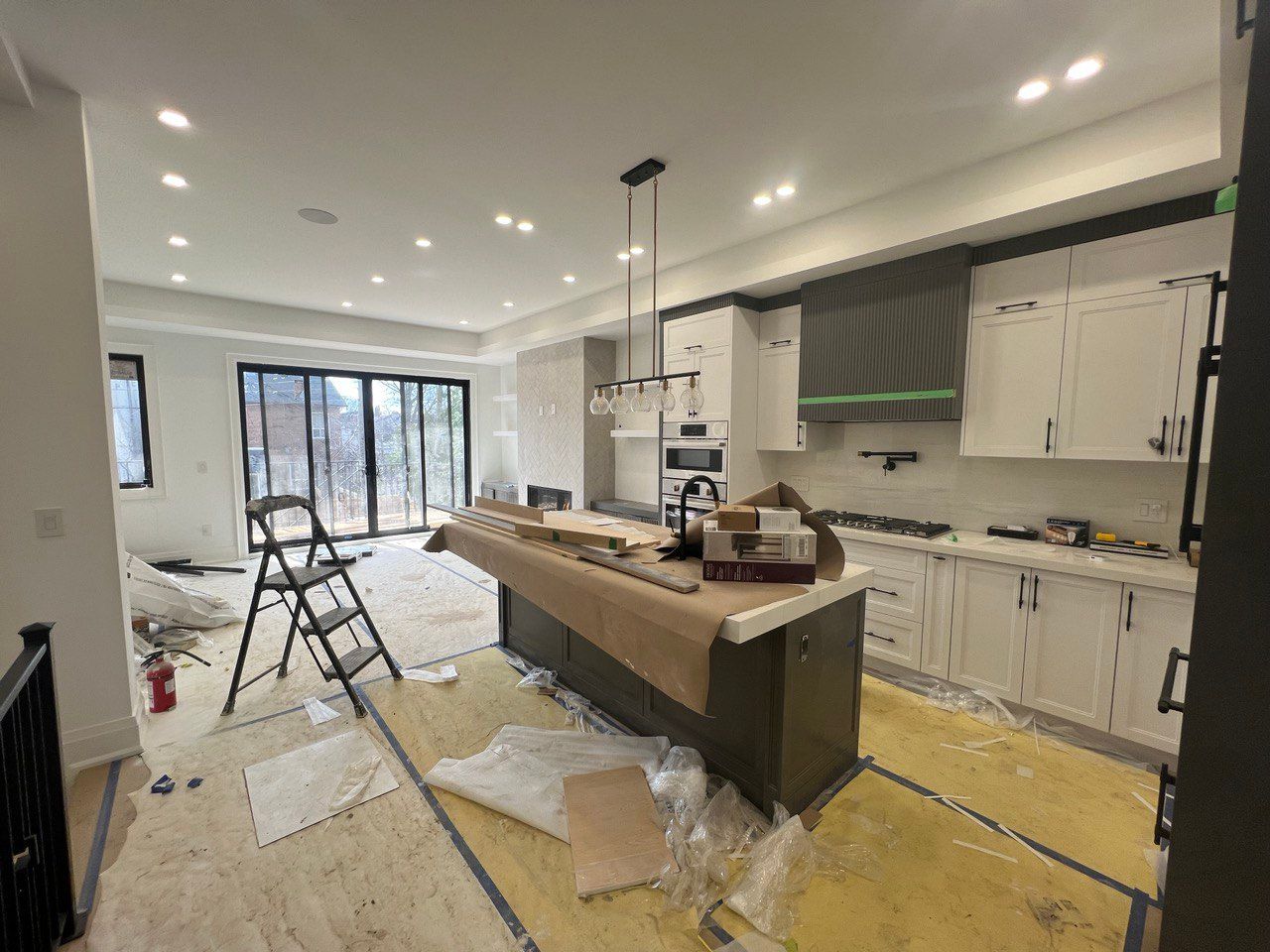 A kitchen under construction with a large island in the middle.