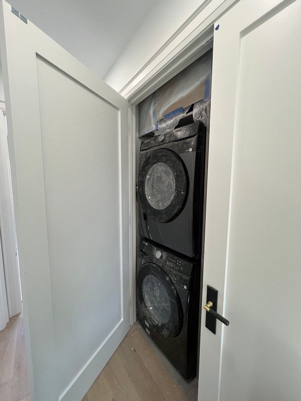 A washer and dryer are stacked on top of each other in a closet.