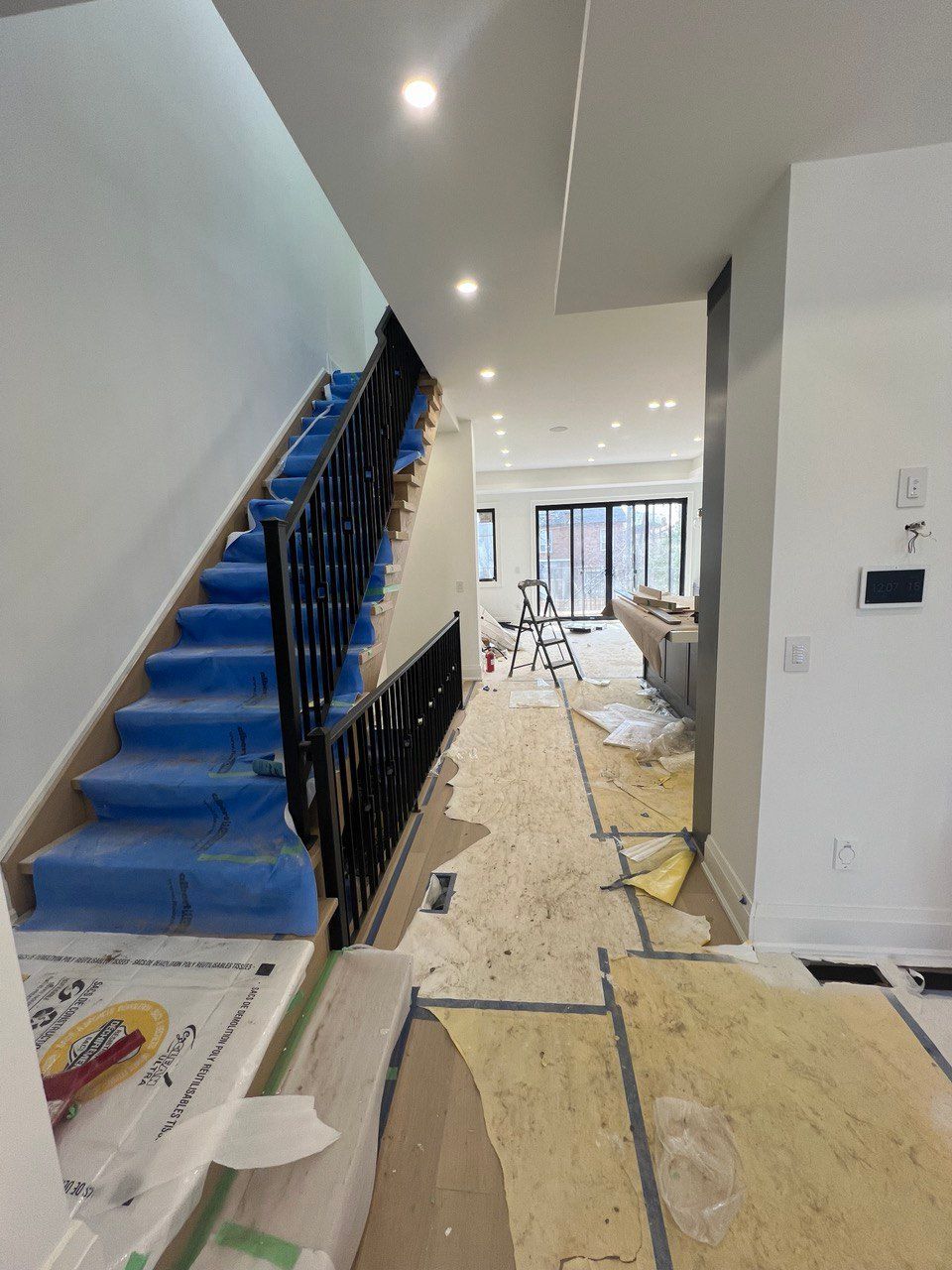 A staircase is being painted in a house under construction
