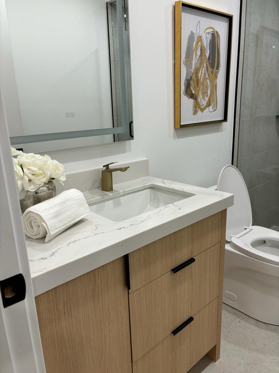 A bathroom with a sink , toilet and mirror.