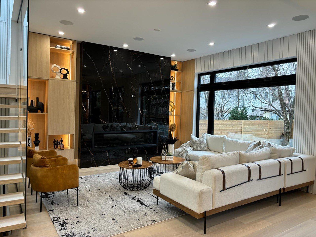 A living room with a couch , chairs , coffee tables and a fireplace.