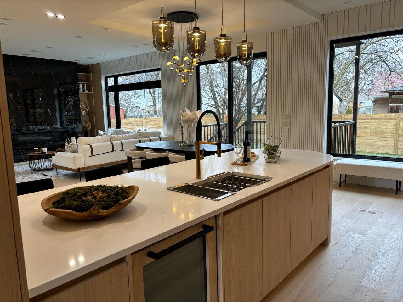 A kitchen with a large island and a sink in a living room.