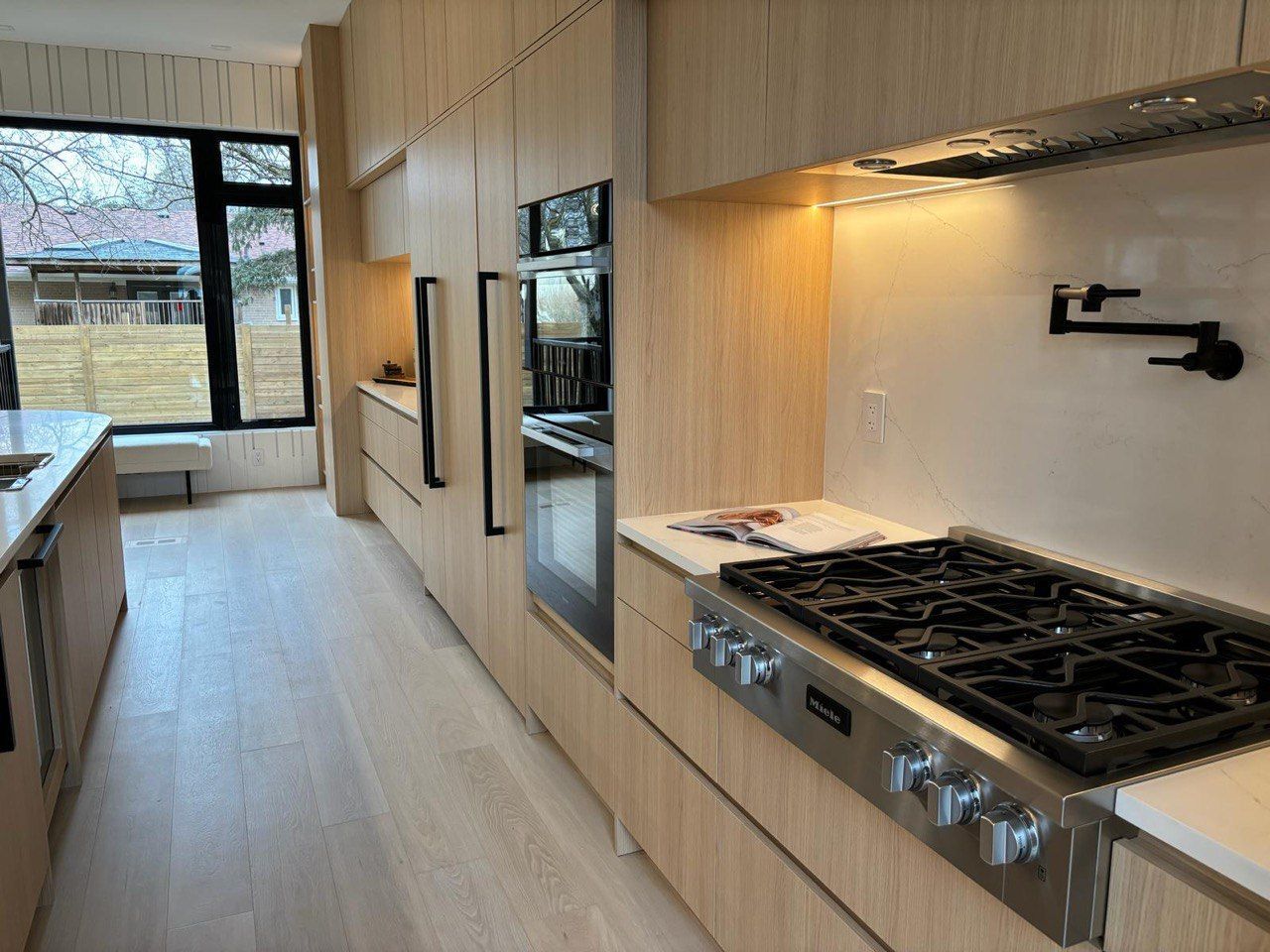 A kitchen with stainless steel appliances and wooden cabinets.