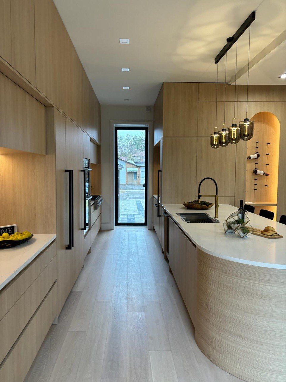 A kitchen with wooden cabinets and white counter tops