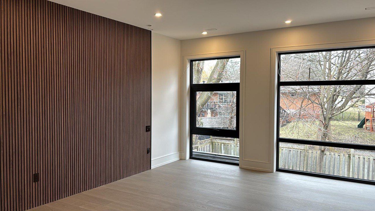 An empty room with a lot of windows and a wooden wall.