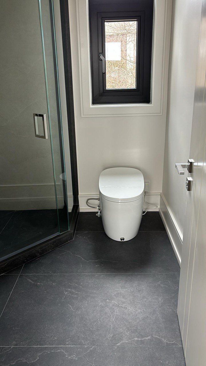 A bathroom with a toilet and a window.
