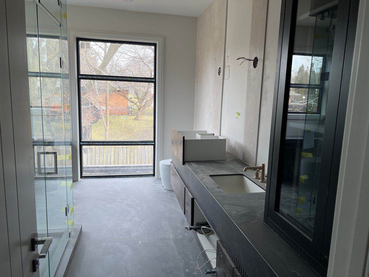 A bathroom under construction with a sink and a large window.