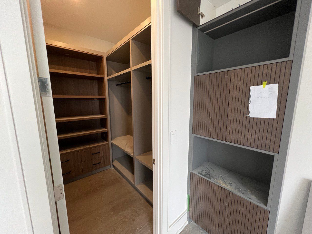 A walk in closet with lots of shelves and drawers in a house.