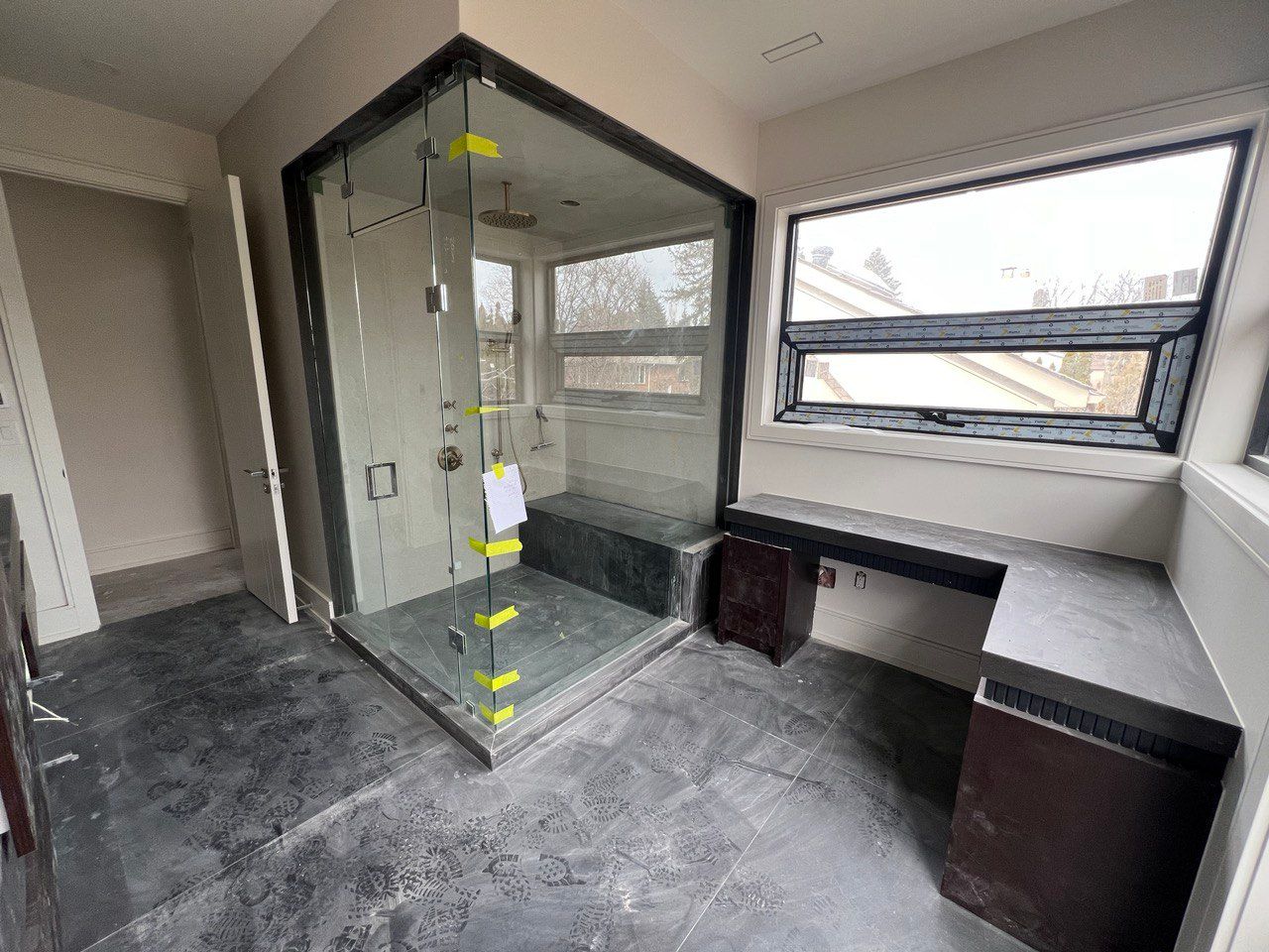 A bathroom with a walk in shower and a window.