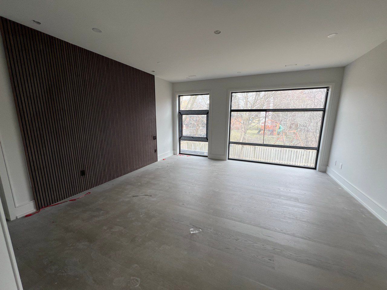 An empty room with a large window and a wall with a pattern on it.