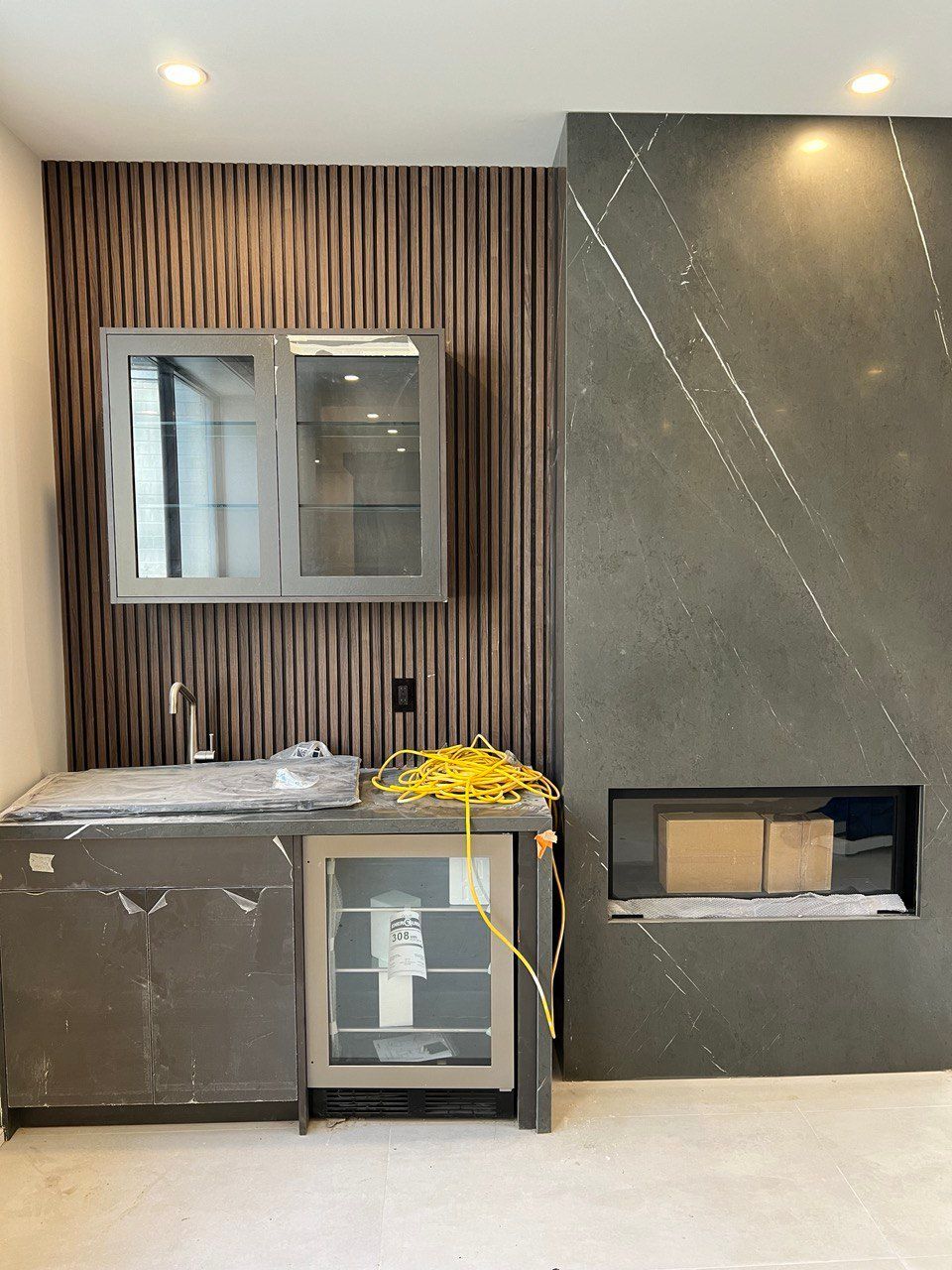 A kitchen with a sink , refrigerator , and fireplace.