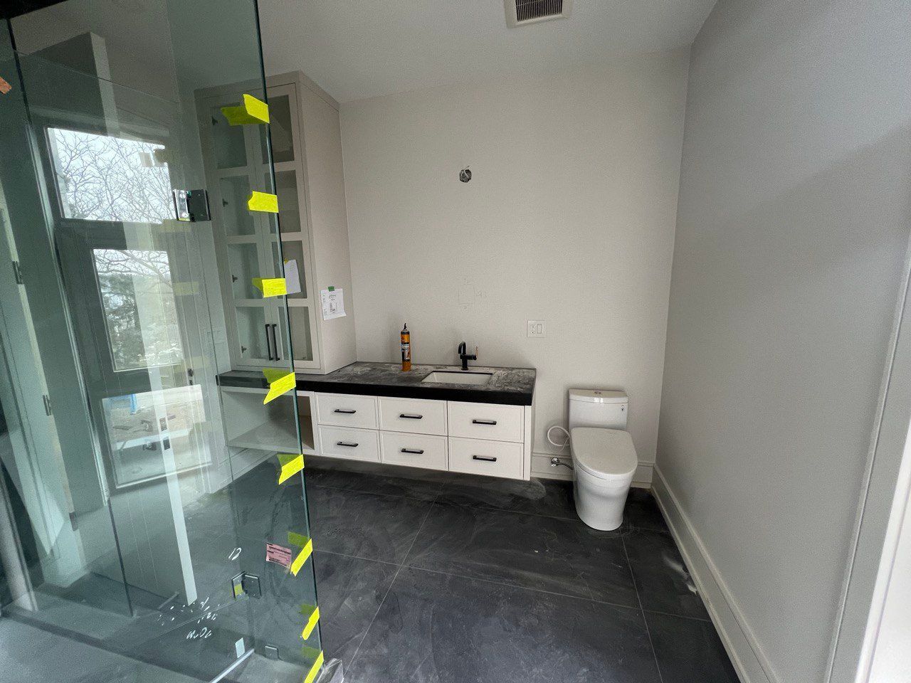 A bathroom with a toilet , sink , and walk in shower.